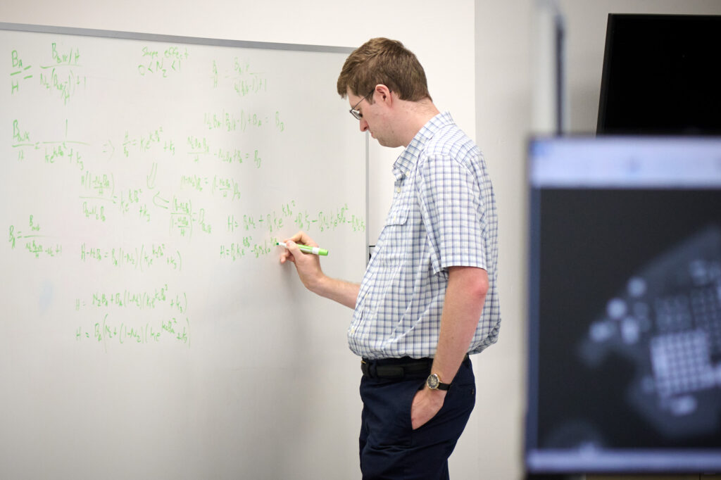 Man doing equations on a board at Intricon